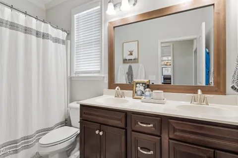 a bathroom with a double vanity sink toilet and a mirror