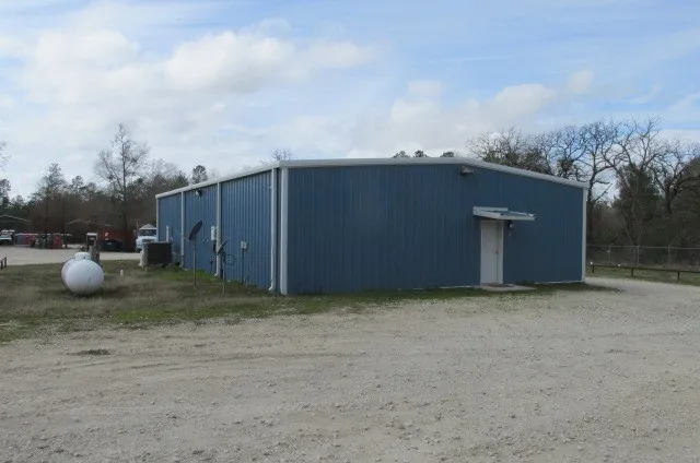 a view of a dry yard with wooden fence