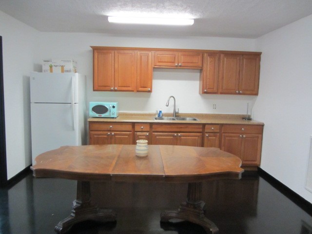 228 Farm To Market Road 3478 Huntsville, TX 77320 - Photo 9 of 28 a kitchen with a table chairs refrigerator and cabinets
