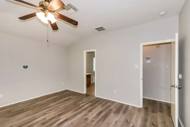 a view of empty room with wooden floor