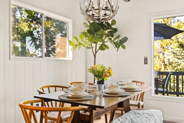 a view of a dining room with furniture a potted plant and a painting