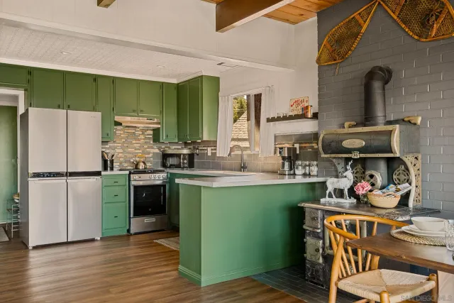 a kitchen with a refrigerator and a stove top oven