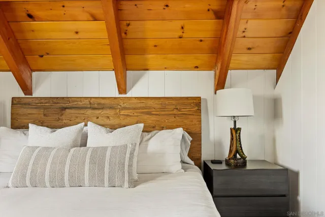 a bedroom with a bed and the view of wooden floor