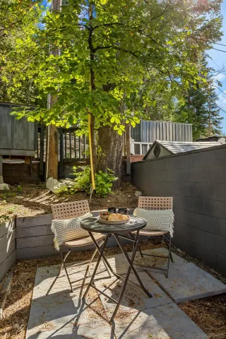 a view of backyard with table and chairs and wooden fence
