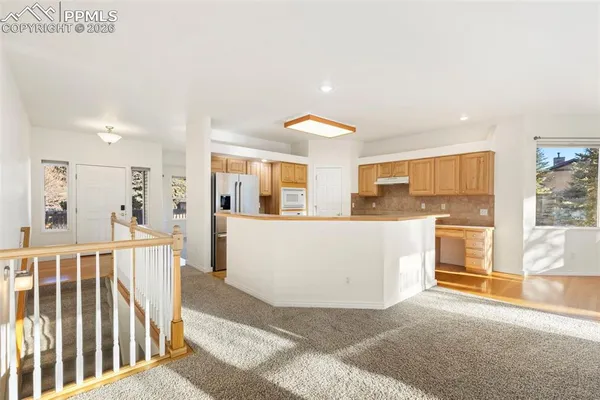 a view of a kitchen with furniture and wooden floor