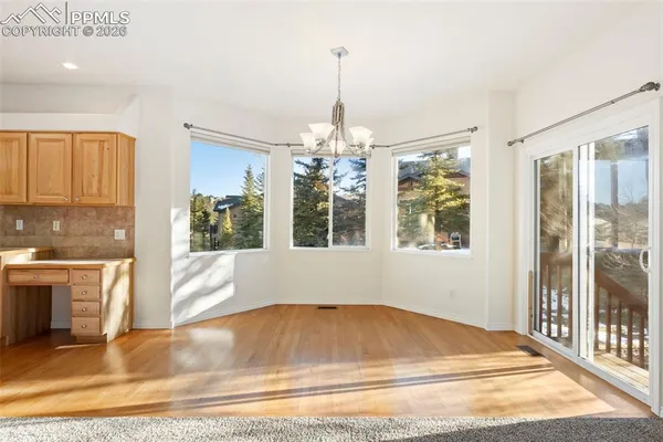 a living room with a large window and chandelier
