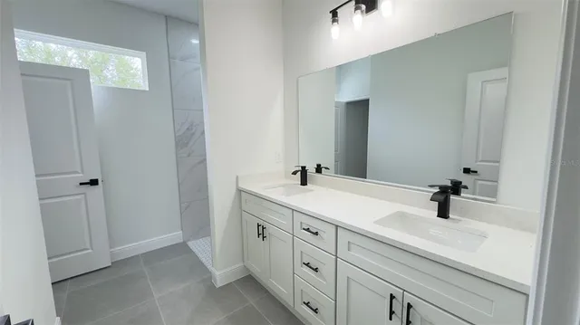 a bathroom with double sink and mirror