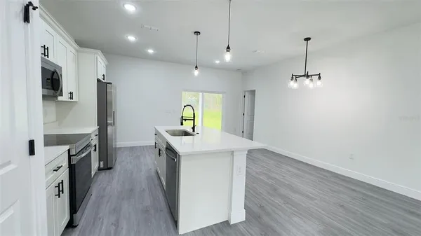 a kitchen with kitchen island white cabinets and stainless steel appliances