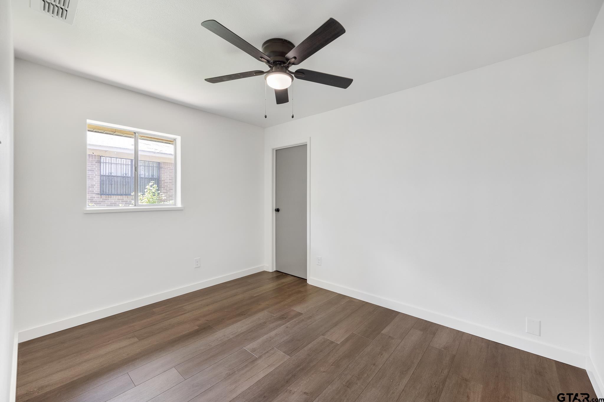 1538 North Hill Road Tyler, TX 75702 - Photo 21 of 29 an empty room with wooden floor and windows