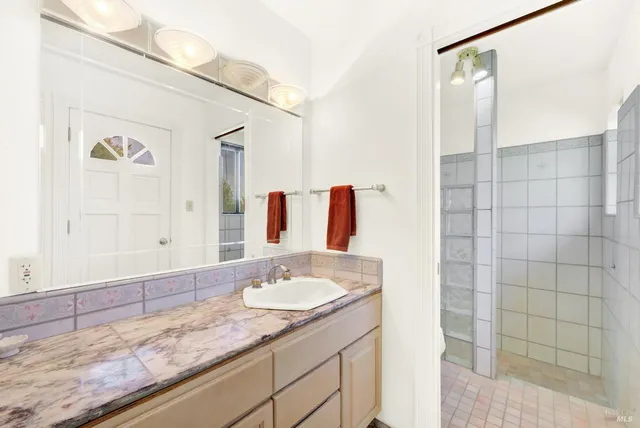 a bathroom with a granite countertop sink toilet and shower