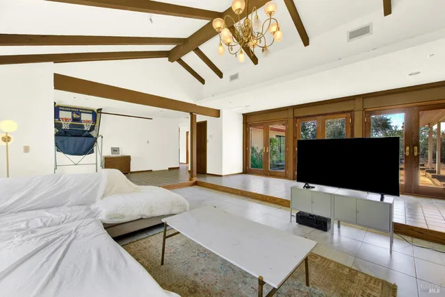 a view of an empty room with wooden floor and windows