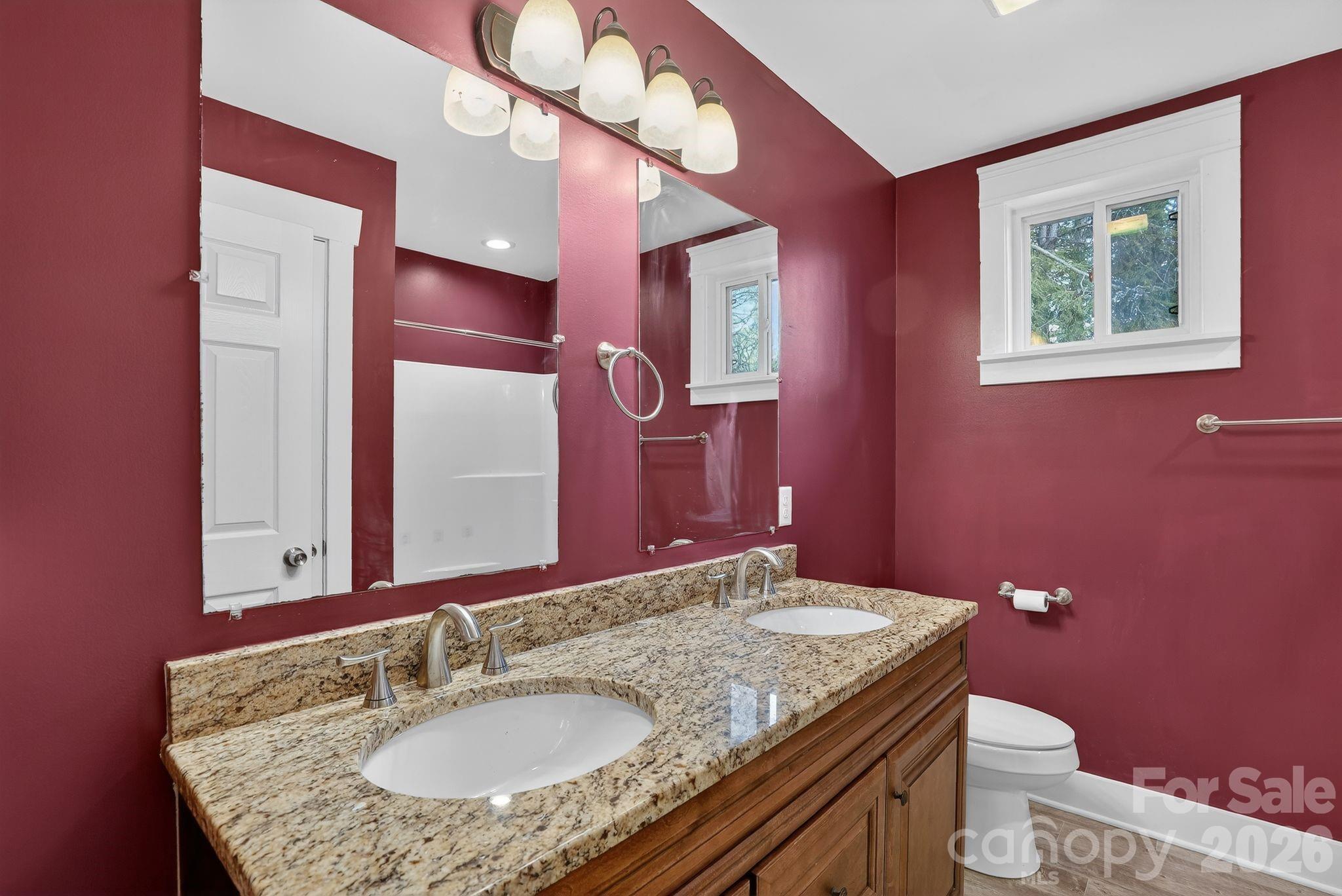 155 North Fork Road Black Mountain, NC 28711 - Photo 18 of 26 a bathroom with a granite countertop sink a toilet and mirror