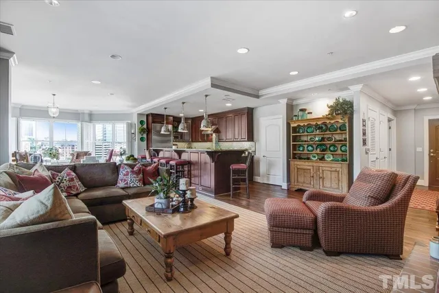 a living room with furniture kitchen view and a large window