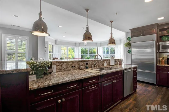 a kitchen with granite countertop a sink and refrigerator