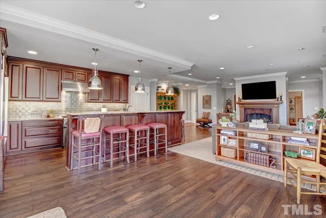 a living room with stainless steel appliances furniture and a wooden floor