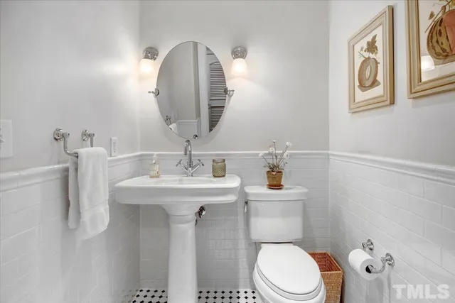 a bathroom with a toilet a sink and mirror