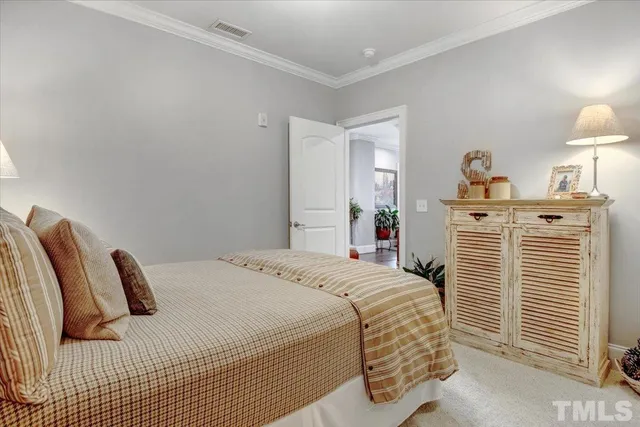 a bedroom with a bed and dresser with mirror