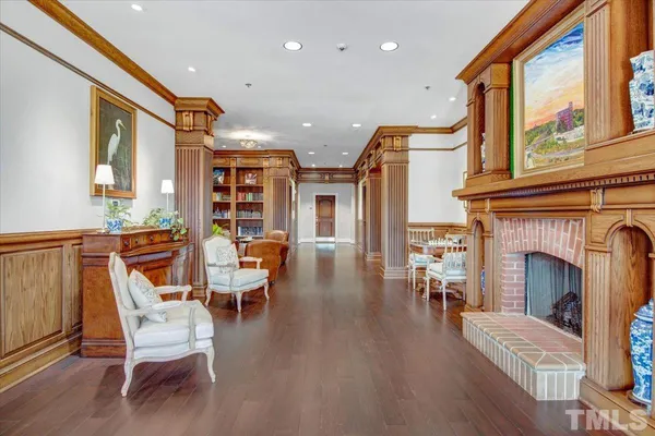 a living room with furniture a fireplace and wooden floor