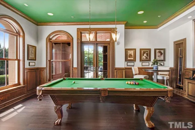 a room with pool table and windows