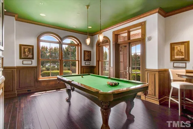 a room with pool table and windows