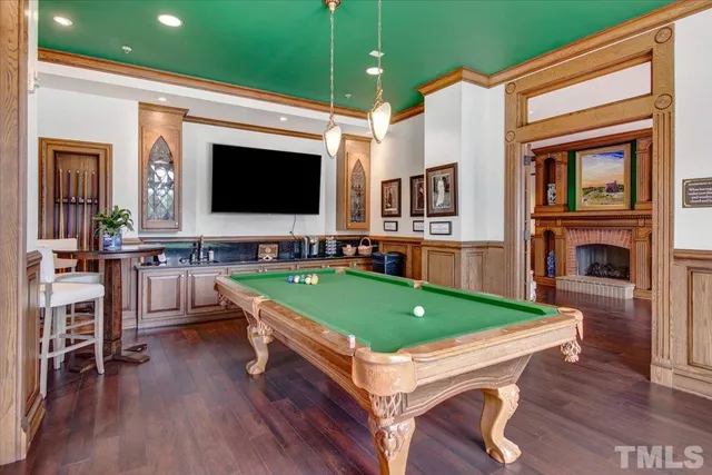 a room with pool table flat screen tv and windows
