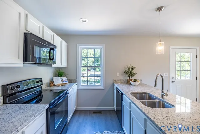 a kitchen that has a sink a stove and wooden floor
