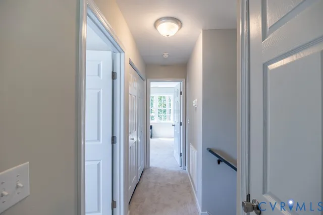 a view of a hallway with a livingroom and a bathroom with sink