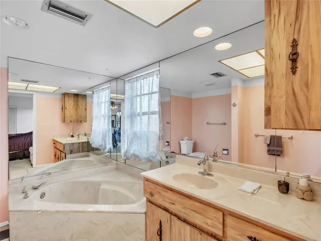 a bathroom with a tub sink and mirror