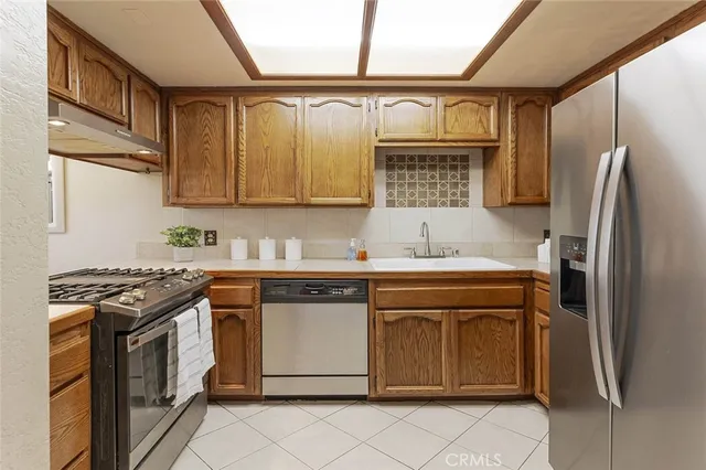 a kitchen with stainless steel appliances granite countertop a stove a sink and a refrigerator