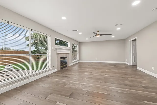 a view of a livingroom with a fireplace wooden floor and window