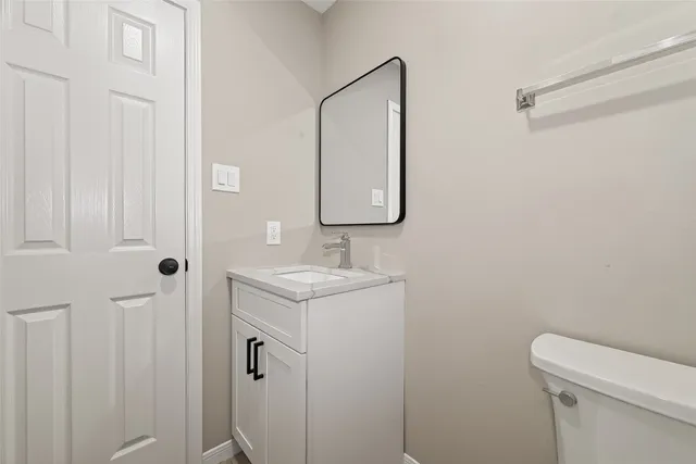 a bathroom with a granite countertop sink a toilet and a mirror