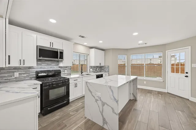 a kitchen with a stove a sink and a refrigerator