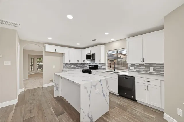 a kitchen with stainless steel appliances kitchen island granite countertop a sink and cabinets