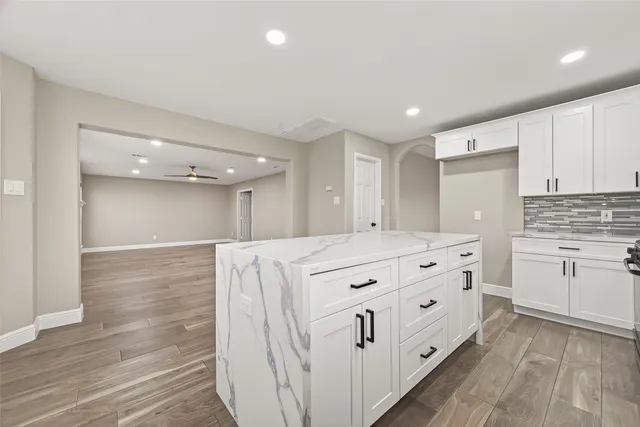 a kitchen with granite countertop white cabinets and white appliances