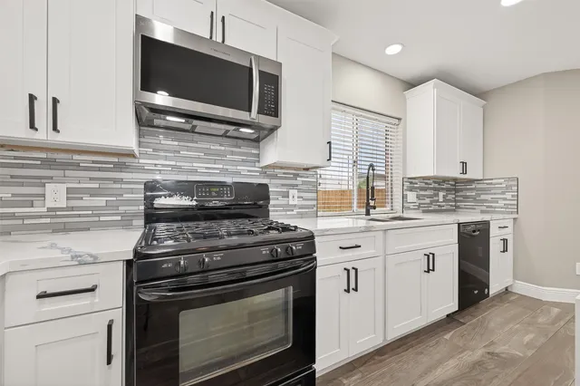 a kitchen with cabinets stainless steel appliances and a sink