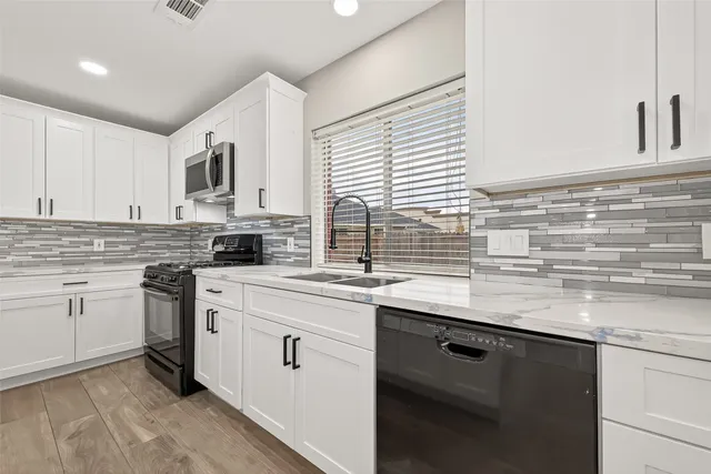 a kitchen with stainless steel appliances granite countertop a sink a stove and cabinets