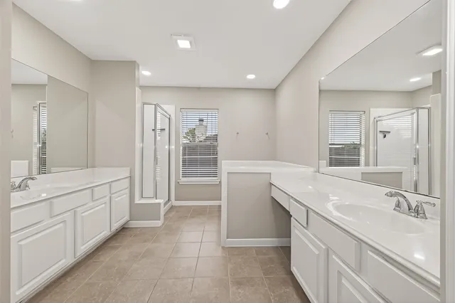 a spacious bathroom with a granite countertop sink a toilet a mirror and shower