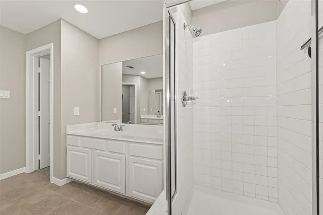 a bathroom with a double vanity sink a shower and a mirror