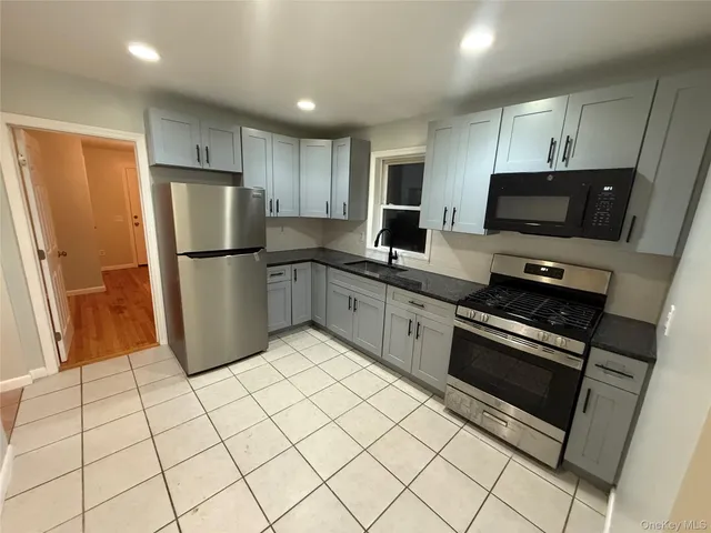 a kitchen with stainless steel appliances a refrigerator sink and microwave
