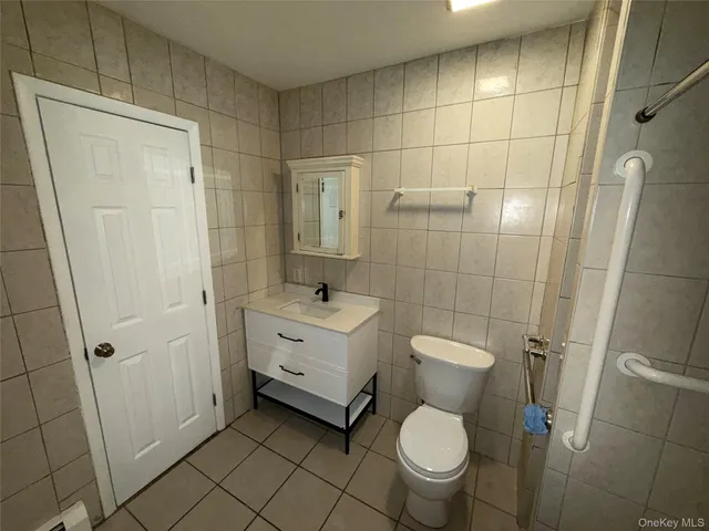 a bathroom with a granite countertop toilet a sink and a shower