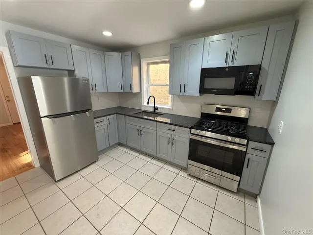a kitchen with stainless steel appliances a refrigerator sink and microwave