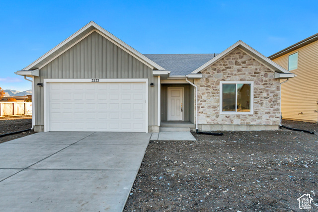 3357 South 960 West Logan, UT 84321 - Photo 2 of 17 Modern ranch home featuring a striking brick and stone exterior, two-car garage with white paneled door, and a freshly poured concrete driveway