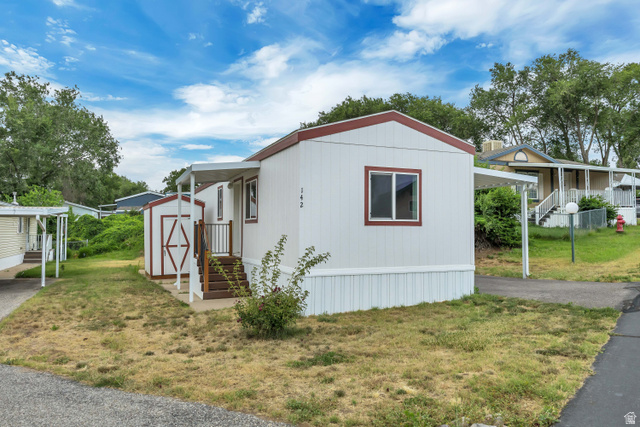 142 Cushing Way Layton, UT 84041 - Photo 13 of 15 White siding exterior with a contrasting red trim roofline and white window frames