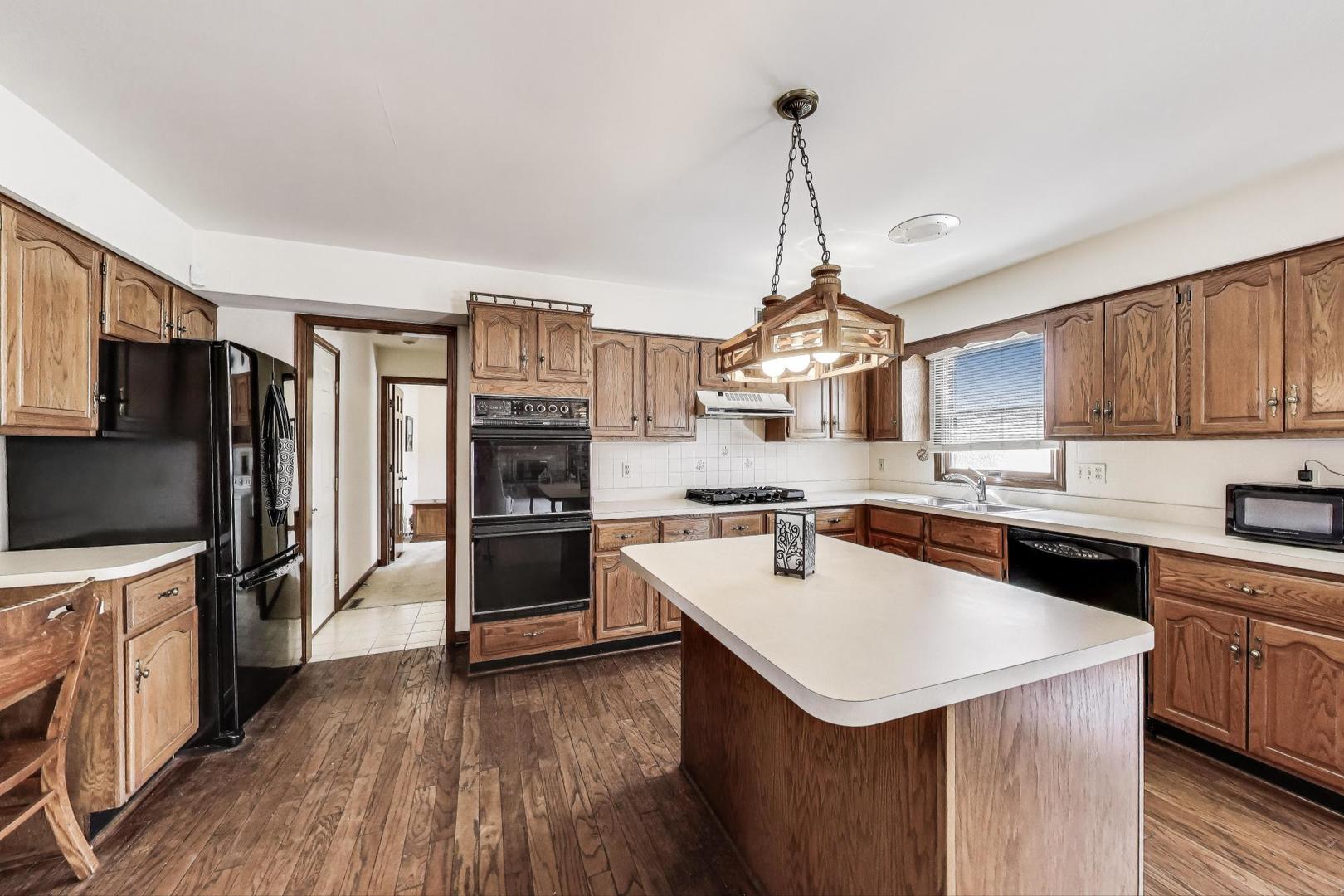 2080 Carolyn Road Aurora, IL 60506 - Photo 11 of 50 a kitchen with a stove a sink dishwasher a refrigerator and a oven with wooden floor