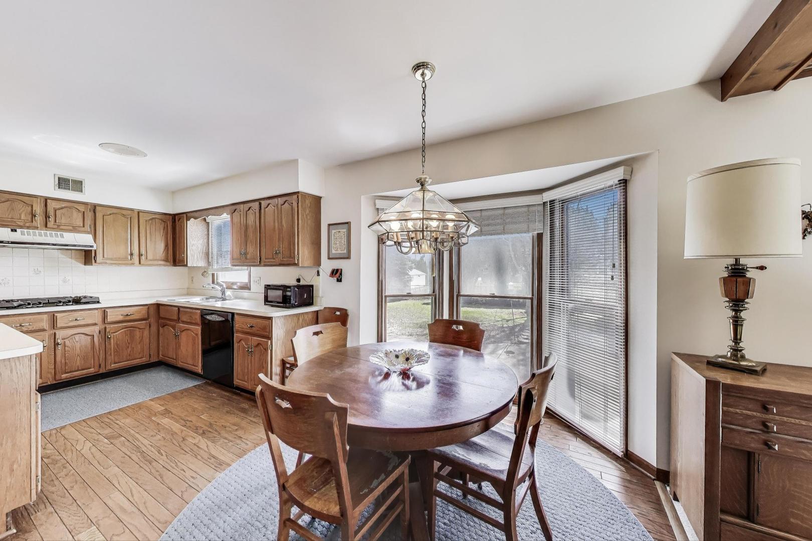 2080 Carolyn Road Aurora, IL 60506 - Photo 15 of 50 a kitchen with stainless steel appliances kitchen island granite countertop a refrigerator a stove a sink dishwasher with a dining table and chairs