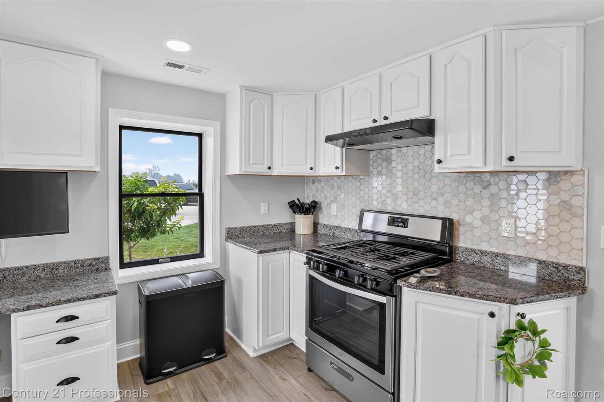 13525 Dennison Road Milan, MI 48160 - Photo 24 of 69 Kitchen featuring white cabinetry, dark speckled countertops, and a full-height hexagonal tile backsplash