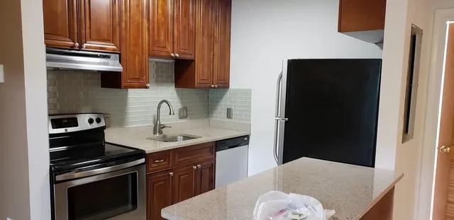 a kitchen with a sink and a stove top oven
