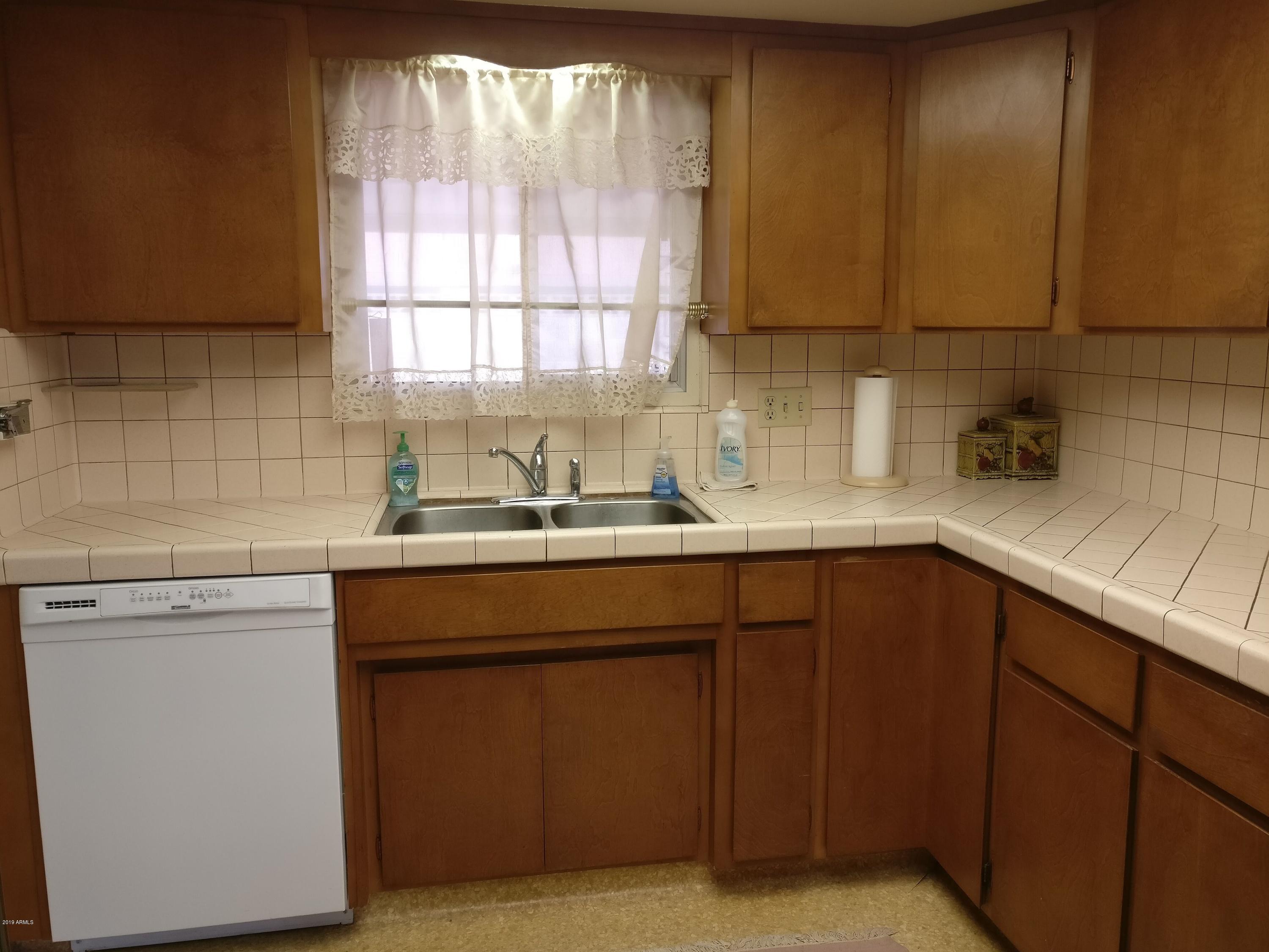 3733 West Ocotillo Road Phoenix, AZ 85019 - Photo 3 of 24 a kitchen with a sink cabinets and window
