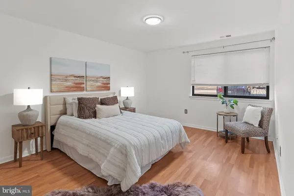 a bedroom with a bed and a wooden floor