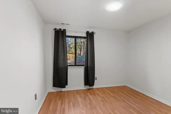 a view of a room with wooden floor and a window